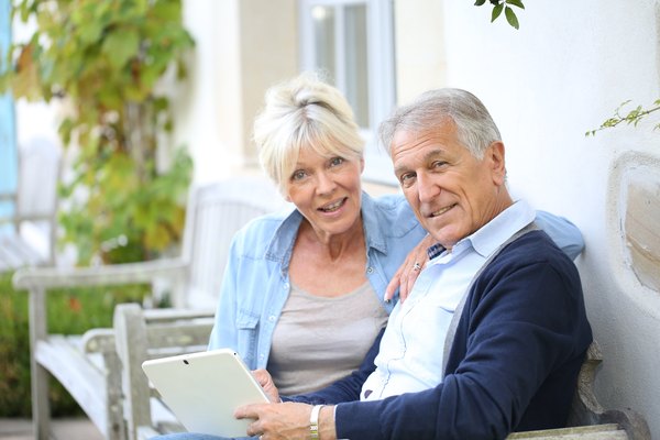 Älteres Paar, das mit Tablet im Internet surft.