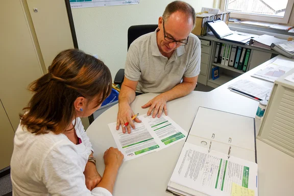 Mitarbeiter der Energie, bei der Energieberatung sitzend am einem Schreibtisch