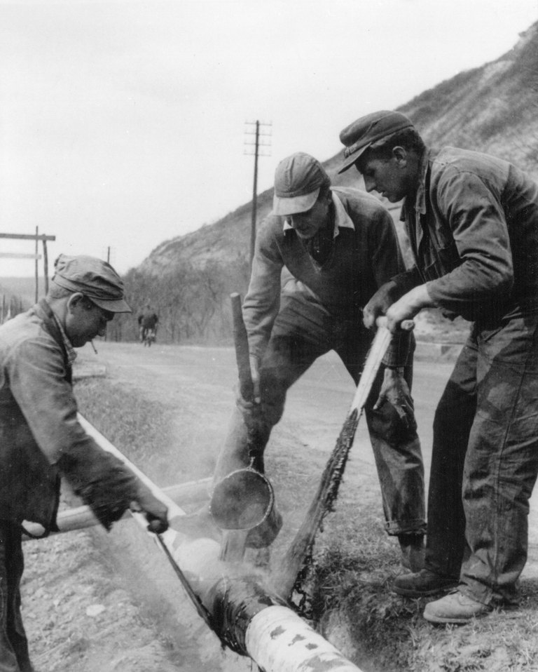 Arbeiter beim Nachisolieren der Schweißnähte an einer Gasleitung, 1952