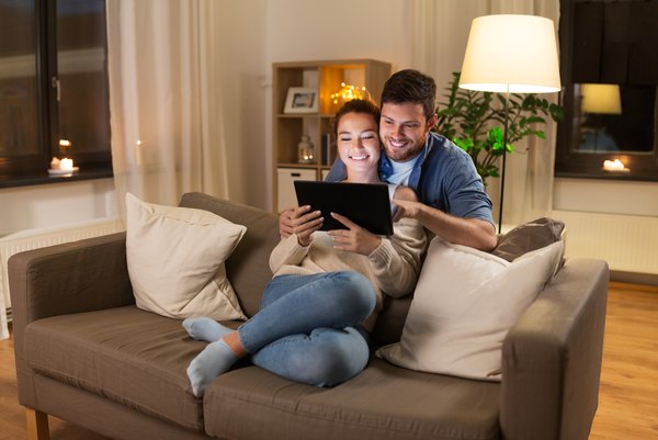  Technologie-, Internet- und Menschenkonzept - glückliches Paar mit Tablet-Computer zu Hause am Abend